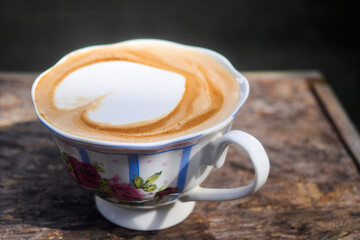 Cappuccino with frothy foam, vintage white cup coffeeon wood background. Flat lay style
