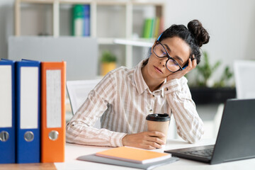 Tired female employee sleeping at work, exhausted woman resting at desk near laptop and folders