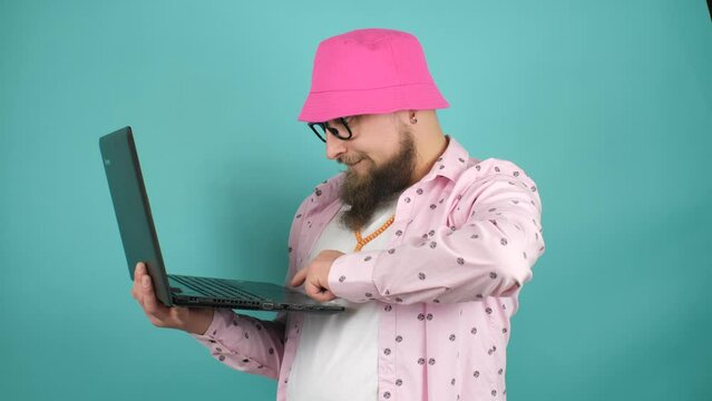 Young crazy bearded charismatic man. Shocked or surprised expression. Laptop concept. Strange programmer, web developer using a laptop.