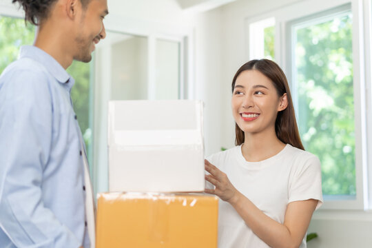 Happy family asian young wife and husband or couple holding carton parcel, carry cardboard box for preparing moving relocation, new home, apartment. Mortgage, real estate, loan for house owner concept