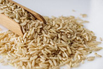 raw unpolished rice on a white acrylic background