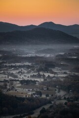 Vertical shot of the Shenandoah valley with mountains and a golden sunset sky in the background