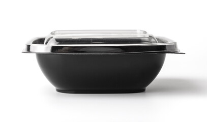 Black plastic food container with a lid on a white background. Close-up