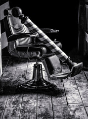 Logo of the barbershop, symbol. Stylish vintage barber chair. Hairstylist in barbershop interior....