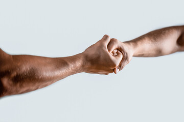 Friendly handshake, friends greeting, teamwork, friendship. Close-up. Rescue, helping gesture or...
