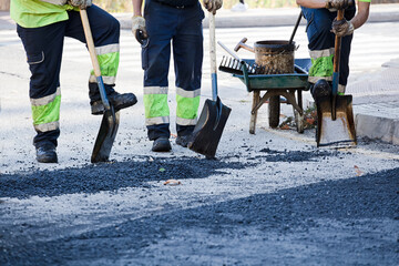 boots of workers in asphalt road construction