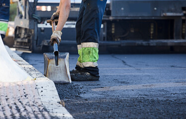 asphalt in wheelbarrow operator prepares mixture with uniform