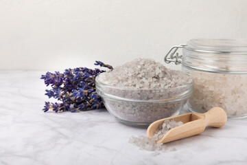 Lavender flowers and fragrant sea salt. The concept of spa, beauty and health salon, skin care cosmetics. Natural cosmetics.Aroma procedures. Close up photo on white wooden background.