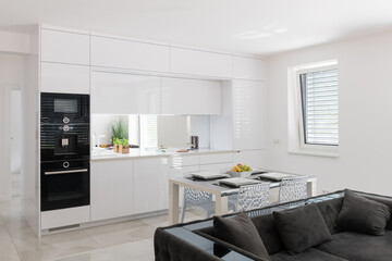 White kitchen with built in appliances in modern apartment