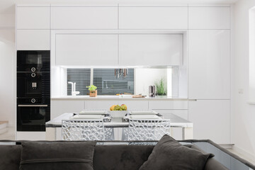 White kitchen with built in appliances in modern apartment