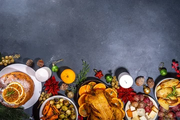 Foto op Plexiglas Christmas or New Year dinner foods on dark table. Set of traditional Xmas party dishes - pannetone, baked chicken, vegetables, potato, cheese and fruits plate, top view copy space © ricka_kinamoto