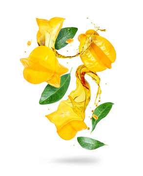 Whole and sliced carambola with juice splashes in the air isolated on a white background