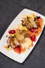 Baked duck breast with pear and carrot garnished with sweet sauce and strawberries. Restaurant concept.