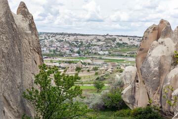 Rocks with caves and city view in a valley in Cappadocia. Magnificent landscape.