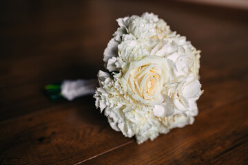 Wedding bouquet of the bride. A beautiful bouquet of white flowers and greenery lies on the table.