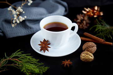 Aesthetics coffee cup with marshmallows, walnuts and spices among Christmas bokeh.