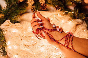 Christmas composition. Women's hands with red beads