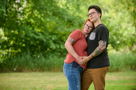 Same sex couple embracing outdoors.