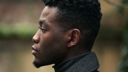 Serious young black African man no emotion expression staring camera, tracking face shot