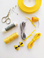 Flat lay with sewing kit and sewing accessories in trend Illuminating yellow and ultimate gray ribbon colours