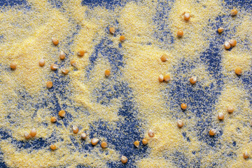 Yellow cornmeal and corn kernels on dark background