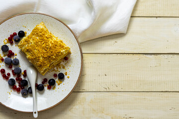 Napoleon cake with berries on a wooden table