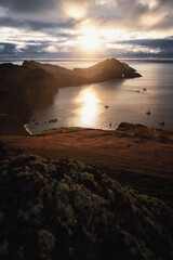 Amazing scenic view from a madeira trip at amazing sunsetlight in the mountsina with a view down to the sea in a moody and foggy but also bright weather.