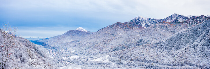 First snow over the italian Alps. Beautiful view of  snowy valley and snowcapped mountain peaks. Christmas feeling. Varaita valley, Piedmont, Italy.