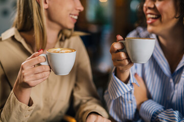close up view of two women drink coffee together