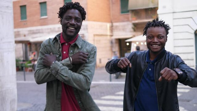 People dance outside in street, two african friends celebrating life dancing