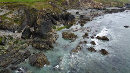 Tidal waves of the Atlantic Ocean near coast of the island of Ireland. Rocky seashore. Seascape, top view. Aerial photo. Drone point of view.