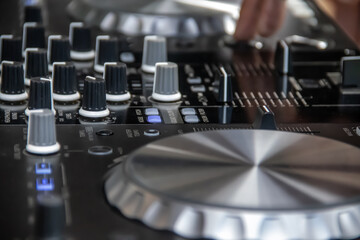 Dick Jockey equipment in night club, CD turntable and mixing equipment, speakers and amplifiers. Hands of DJ over the turntable in the night club