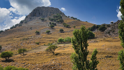 landscape of an imposing volcanic mountain and sky cloud with various trees on the slope of the valley, Imbros Island, Gokceada, Canakkale Turkey