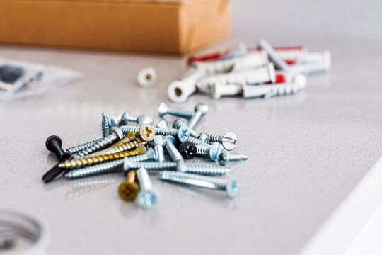 Un conjunto de tornillos y tacos  sobre una mesa de m&aacute;rmol gris. Concepto de herramientas para una reforma. Bricolaje.