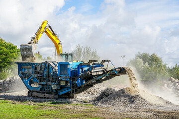 Mobile concrete and reinforced concrete construction debris shredding machine in operation - obrazy, fototapety, plakaty