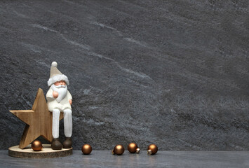 Weihnachtsmann mit Stern und Weihnachtskugeln vor einer Marmorwand nit Platz für Text. - obrazy, fototapety, plakaty