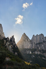 rays of light crossing the mountains in montserrat at sunset with some autumn colors