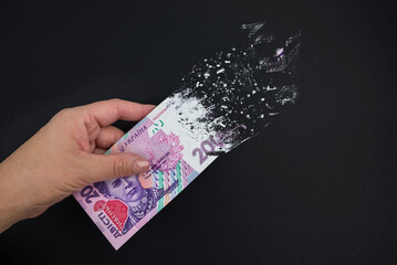 Inflation, dollar hyperinflation. A bill of 200 Ukrainian hryvnia is sprayed in a hand on a black...