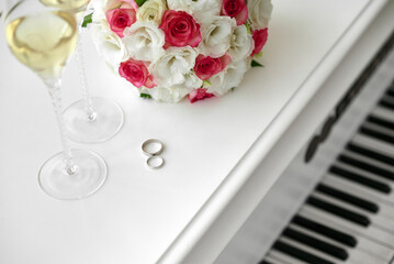 Wedding rings and bouquet on background