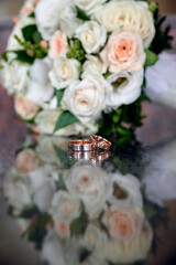 Wedding rings and bouquet on background