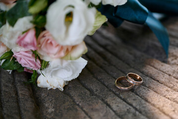 Wedding rings and bouquet on background