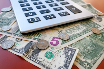 Close-up of American money - coins and banknotes - with calculator  