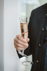 Holding a glass with sparkling wine in grooms hand - 548318829