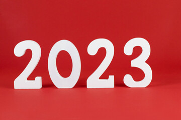 Year 2023 white, wooden numbers on a red background. Place for text. Copy space concept, holiday, plan, party, new year, invitation, congratulation, postcard, template, 