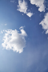 Beautiful whimsical clouds against the blue daytime sky.Vertical frame