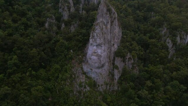 Aerial video of the statue of Decebal, located on the gorges of Danube river in Romania. Video was shoot from a drone with camera lowered with the statue in the view.