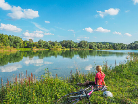 Rennrad fahren n&ouml;rdlich von M&uuml;nchen - Radfahrerin macht Pause am See