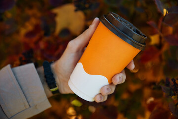 Person holds cup of coffee and enjoys autumn weekends
