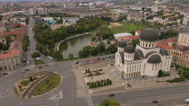 Aerial video shot from a drone while flying forward and lowering altitude. In the footage can be seen the orthodox cathedral in Arad city, Romania and a busy intersection.