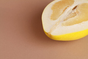 Close up ripe juicy fresh cut sliced yellow Pomelo on brown color background. Shaddock, citrus...